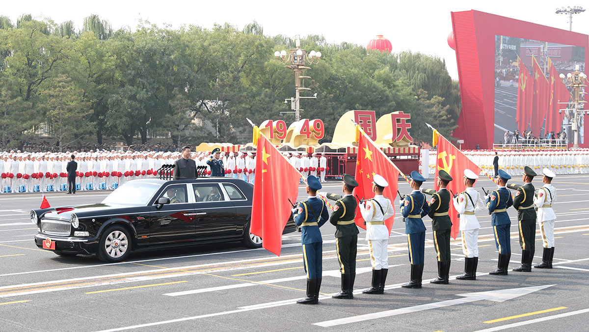 習近平驅(qū)車行進至黨旗、國旗、軍旗前，向旗幟行注目禮