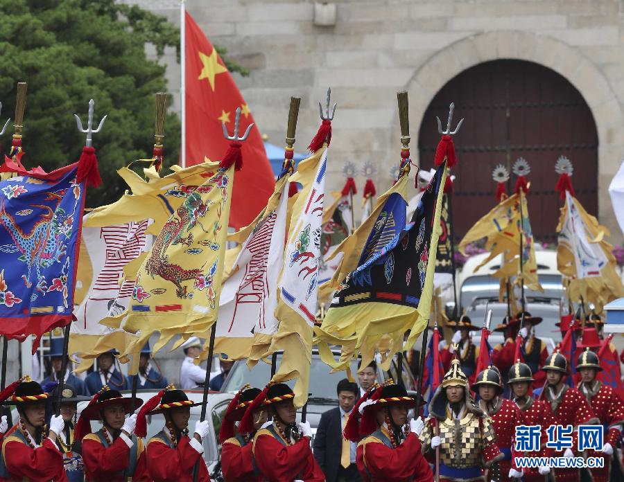 7月3日，韓國總統(tǒng)樸槿惠在青瓦臺總統(tǒng)府舉行隆重儀式，歡迎中國國家主席習(xí)近平對韓國進(jìn)行國事訪問。這是習(xí)近平的車隊(duì)在身著民族服裝的韓國禮儀隊(duì)伍引導(dǎo)下駛?cè)肭嗤吲_。新華社記者丁林?jǐn)z  